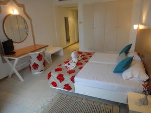 a bedroom with a bed and a desk and a mirror at Aylimas Family Hotel in Monastir +18 photos