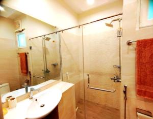 a bathroom with a glass shower and a sink at Luxe Villa in Murree +50 photos