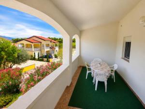 a balcony with a table and chairs and a garden at Apartman Adriatic View in Vir