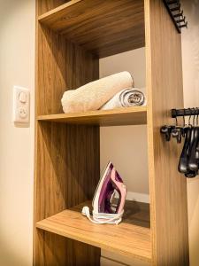 a wooden shelf with a pink purse on it at Blossom Bliss in La Norville +4 photos