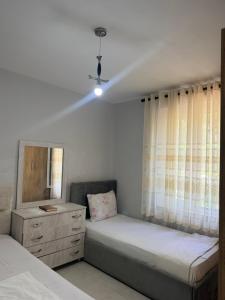 a bedroom with two beds and a dresser and a window at Bella Vista Apartment in Lezhë