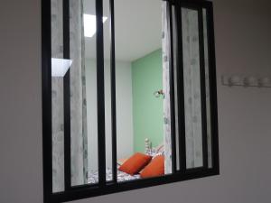 a mirror reflecting a room with a couch in a room at Chambre Jasmin in Maubec