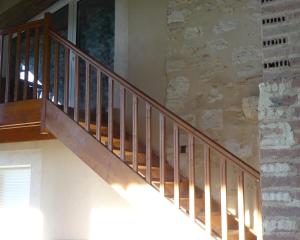 a staircase in a house with a stone wall at Chambre Jasmin in Maubec