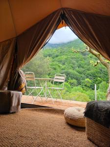 a tent with two chairs on a wooden deck at Nova Forest Montseny in Montseny