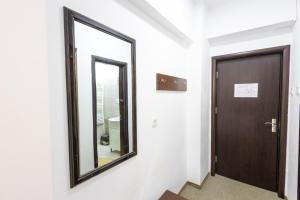 a mirror on a wall next to a door at Hotel Venus in Slănic-Moldova