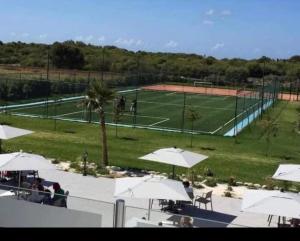 a tennis court with white umbrellas and a tennis court at Villa Savannah Beach in Sidi Rahal +6 photos