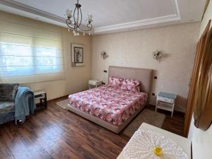 a bedroom with a bed and a table and a window at Villa Savannah Beach in Sidi Rahal