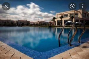 a swimming pool with a metal object in the water at Villa Savannah Beach in Sidi Rahal