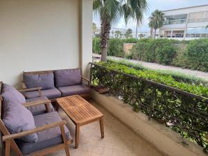 a balcony with chairs and a couch and a table at Villa Savannah Beach in Sidi Rahal