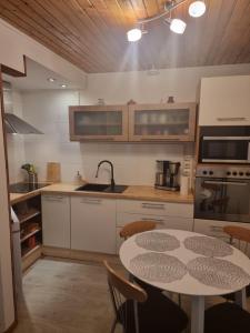 a kitchen with a table and a table and chairs at Spacious home with balcony! in Pärnu
