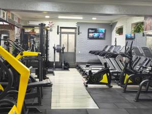 a gym with rows of treadmills and machines at Best Guest House in Andizhan