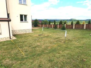 a yard with a net in the grass at Penzion Renesance in Drnovice