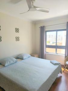 a bedroom with a bed with a ceiling fan and a window at Vacaciones en el paraíso in Lagoa +13 photos