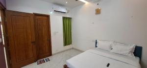 a bedroom with a bed and a door and a window at The Green stays in Madurai