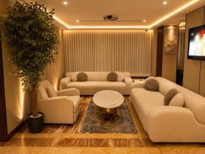 a living room with two couches and a table at IQ Hotel alhamra فندق اي كيو الحمراء in Jeddah