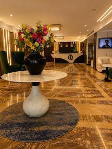 a vase of flowers on a table in a lobby at IQ Hotel alhamra فندق اي كيو الحمراء in Jeddah