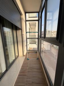 a hallway of a building with windows and a ladder at Nakhla2 in Dar Bouazza