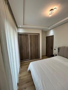 a bedroom with a white bed and a window at Nakhla2 in Dar Bouazza