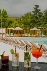a group of drinks on a table next to a pool at Park Hotel Tskaltubo - Balneo Resort in Tsqaltubo