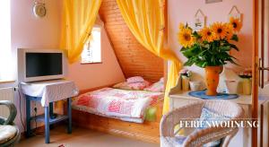 een kleine slaapkamer met een bed en een televisie bij Potsdamer Ferienwohnung in Potsdam