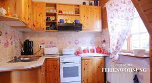 a kitchen with wooden cabinets and a white stove top oven at Potsdamer Ferienwohnung in Potsdam +3 photos
