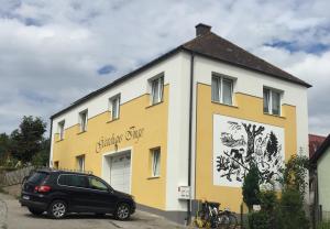 Braunegger-Hof Waldviertel في Braunegg: سيارة سوداء متوقفة أمام مبنى أصفر وبيضاء