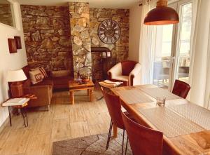 a living room with a table and a stone wall at Charming Apartments am See in Bad Saarow