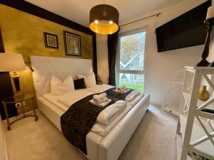 a bedroom with a white bed and a window at Charming Apartments am See in Bad Saarow