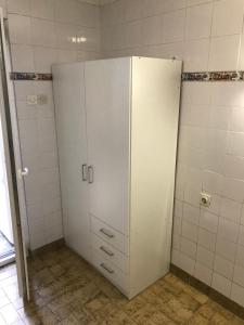 Ein weißer Schrank in einem Badezimmer mit weißen Fliesen in der Unterkunft Maleni Studio in Zaostrog