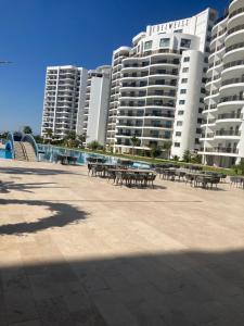 a group of tables and benches in front of buildings at Caesar Resort spa in Dherinia