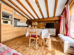 a kitchen with wooden cabinets and a table and chairs at Chaleureux appartement au pied des pistes avec parking et animaux admis - FR-1-505-65 in Notre-Dame-de-Bellecombe