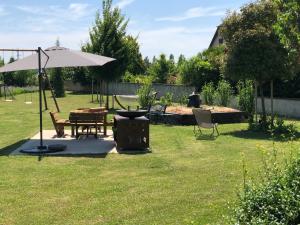 a picnic table and an umbrella in a yard at Les Loges Du Ried in Marckolsheim
