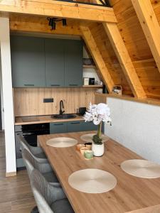 a kitchen with a wooden table with chairs at V Chalet in Žabljak