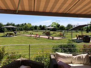 a view of a park with chairs and tables at Les Loges Du Ried in Marckolsheim