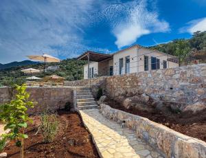 a house with a stone wall and a stone staircase at Villa Thea with Pool & panoramic Sea View in Kotrónion