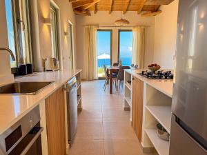 a kitchen with a sink and a counter with a table at Villa Thea with Pool & panoramic Sea View in Kotrónion