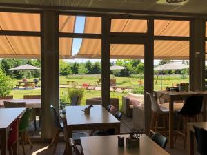 a restaurant with tables and chairs and large windows at Les Loges Du Ried in Marckolsheim +88 photos