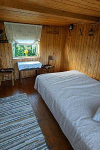 a bedroom with a bed and a sink and a window at Little Red Sauna by the Sea in Leesi