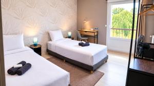 a hotel room with two beds and a window at Appartement Les Oiseaux in Thionville