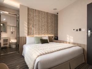 a bedroom with a large bed and a bathroom at V-one Hotel - Ningxia No. 2 Inn in Taipei