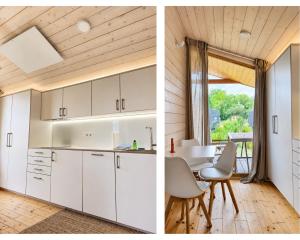 eine Küche und ein Esszimmer mit weißen Schränken und einem Tisch in der Unterkunft 308-Tiny House Inn in Bleckede