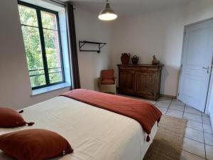 a bedroom with a large bed and a window at Gîte spacieux en campagne avec jacuzzi, sauna et jeux extérieurs - FR-1-496-52 in Saint-Just-la-Pendue