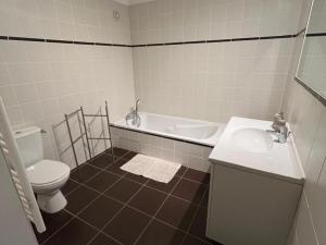 a bathroom with a toilet and a tub and a sink at Gîte spacieux en campagne avec jacuzzi, sauna et jeux extérieurs - FR-1-496-52 in Saint-Just-la-Pendue +28 photos