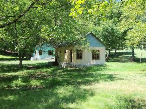 a small house in the middle of a field at Gurbanefendi forest cottages in Qurbanǝfǝndi