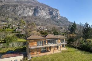 a wooden house with a mountain in the background at Wooden Villa 4 in Veyrier-du-Lac