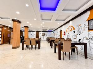 a dining room with tables and chairs and a blue ceiling at The Binapani Hotel And Restaurant in Tarapith