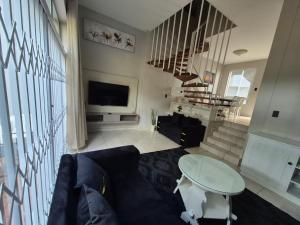a living room with a couch and a tv at 18 Ipanema Beach in Durban