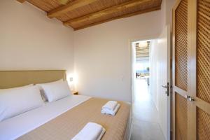 a bedroom with a bed and a door to a balcony at Giourgas Studios & Apartments in Provatas