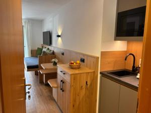 a kitchen with a sink and a counter with a bowl of fruit at Alpenrösle Ferienwohnungen - Berge - Ruhe - Traumaussicht 1-, 2- und 3-Raum-Wohnungen, Panoramasauna in Balderschwang