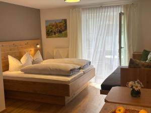a bedroom with a large bed and a window at Alpenrösle Ferienwohnungen - Berge - Ruhe - Traumaussicht 1-, 2- und 3-Raum-Wohnungen, Panoramasauna in Balderschwang